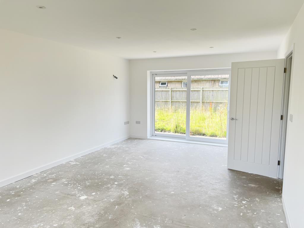 Lot: 125 - FOUR-BEDROOM HOUSE FOR COMPLETION IN POPULAR SETTING - Living room with sliding doors to garden
